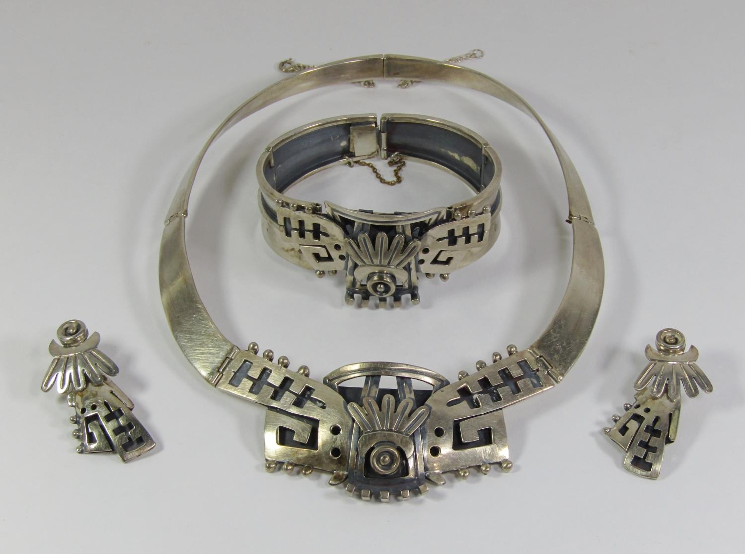 Mexican stylised silver jewellery suite comprising collar necklace, cuff bracelet and pair of drop