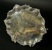A small George II silver salver with ogee scroll and shell rim, raised on three pad feet, London