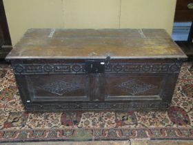 A 17th century and later oak coffer, with geometric repeating carved detail and ironwork handles,