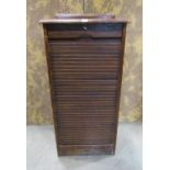 A vintage oak floor standing pedestal filing cabinet enclosed by a rise and fall tambour door with