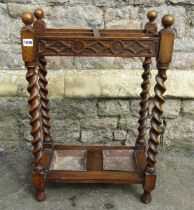 A 1920s oak four divisional umbrella/stick stand on barley twist supports