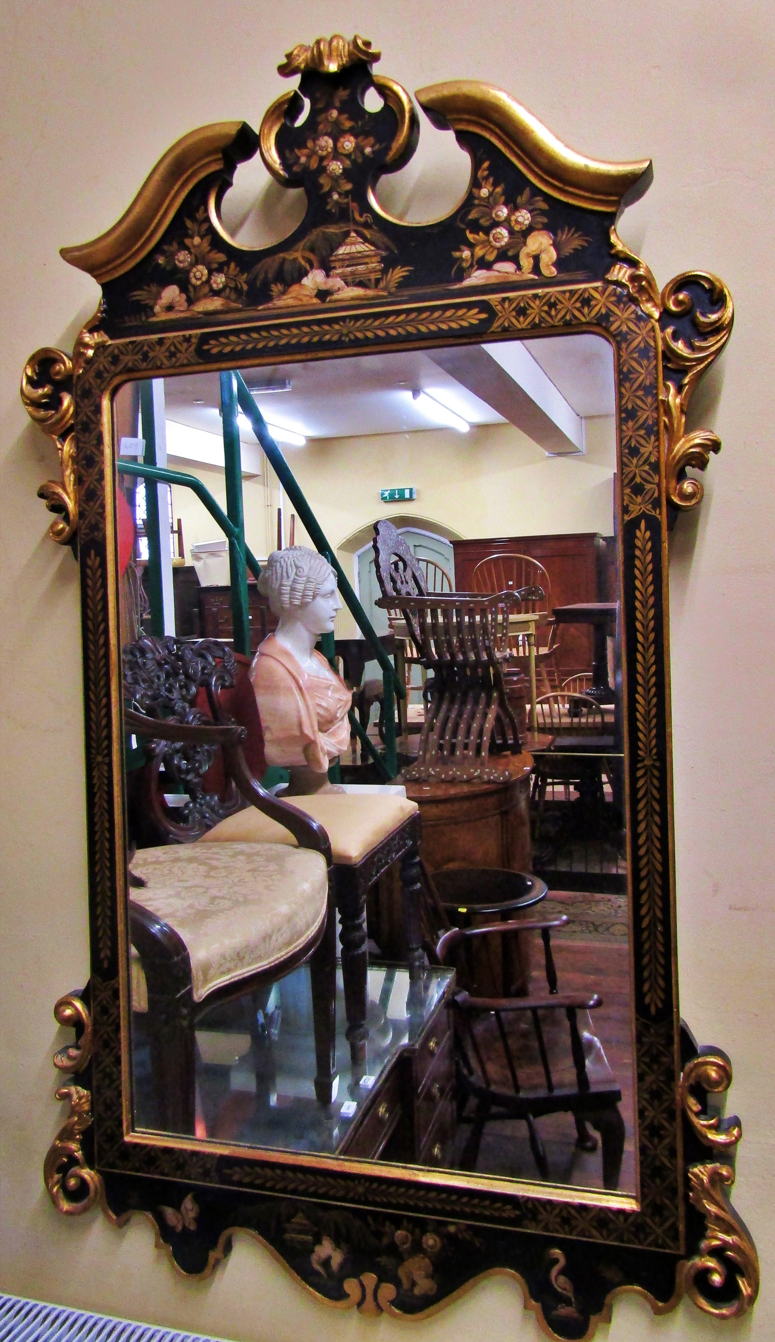 An 18th century style wall mirror with chinoiserie detail frame in black and gilt, set beneath a