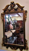 An 18th century style wall mirror with chinoiserie detail frame in black and gilt, set beneath a