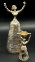 A silver table bell in the form of a dancing woman, with English hallmarks, together with a