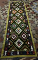 A Maimana Kilim Runner with a lime green border around a field of stepped diamond medallions 292cm x