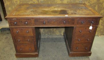 An Edwardian oak pedestal desk with a distressed leather lined top on twin pedestals both with three