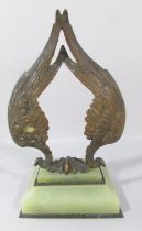 A Bronze Double Angel wing watch stand set on a green onyx base.