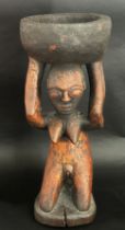 An old African carved hardwood figural tazza / vessel, in the form of a nude figure kneeling,