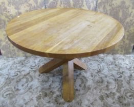 A contemporary oak circular breakfast table raised on a criss cross of three square supports,