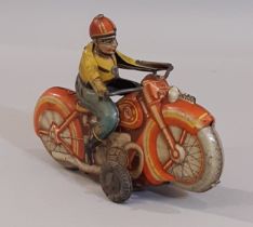 A vintage clockwork tin plate motorcycle and rider, made in West Germany. Length 16cm