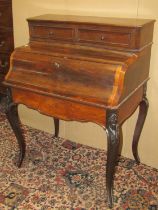 A 19th century French rosewood bonheur du jour, the serpentine fall front enclosing a maple-lined