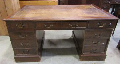 A Georgian style kneehole twin pedestal mahogany desk with inset leather top over the usual