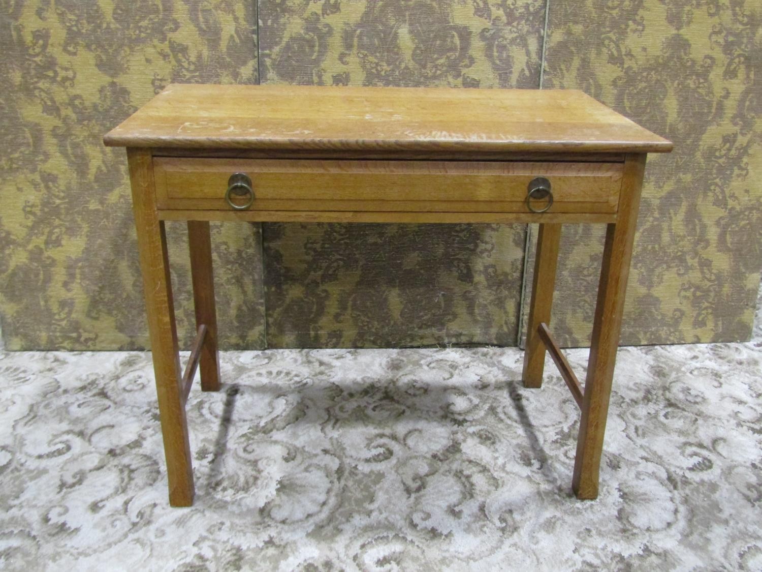An Arts & Crafts oak side table with shallow frieze drawer raised on square cut and moulded