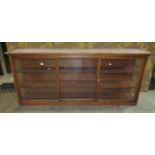 A pitch pine framed side cabinet enclosed by a pair of rectangular glazed panelled doors, 72 cm high