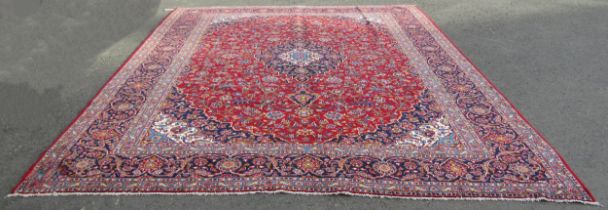 A Persian Kashan carpet with rich red ground and traditional floral medallion, 393cm x 300cm