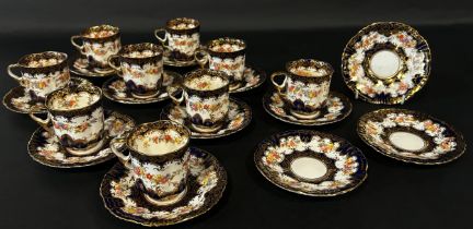 A collection of Staffordshire coffee wares comprising eleven tea cups and saucers with floral sprays