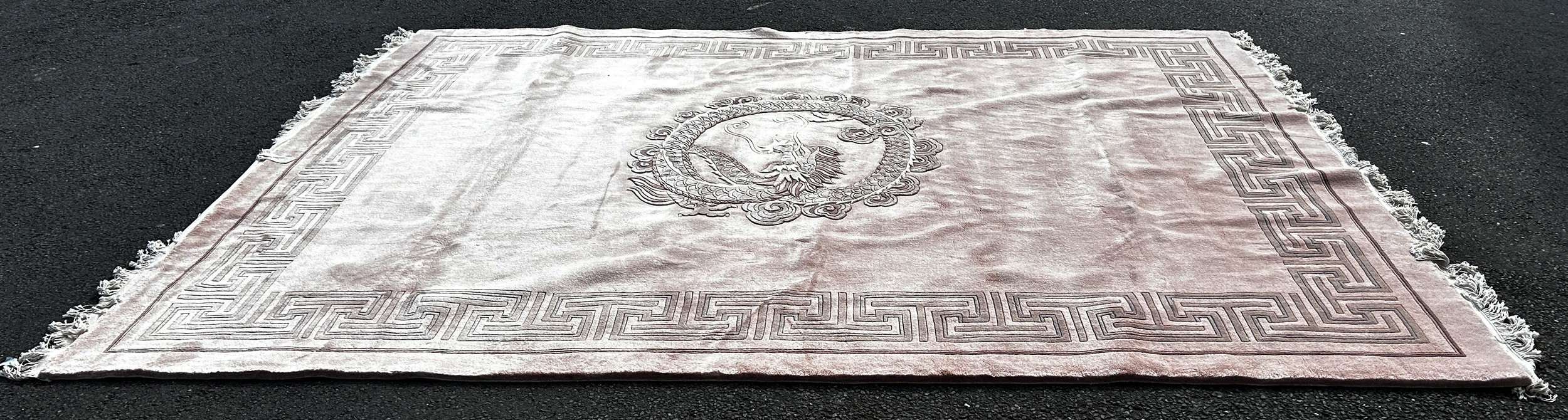 A large Chinese pink thick wool pile carpet with a coiled dragon to the centre and a geometric - Image 2 of 3