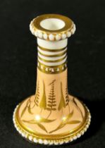 A miniature Spode taper stick with beaded borders on a pale salmon ground, overlaid with gold detail