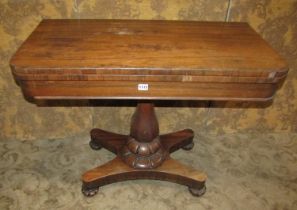 A 19th century rosewood fold over top card table raised on a vase shaped pillar