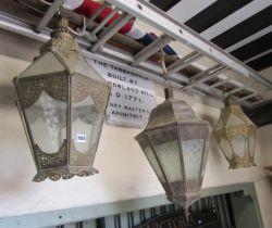 A pair of Eastern hanging brass lanterns with glazed panels and pierced detail together with one