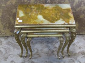 A nest of three graduated occasional tables with inset onyx tops raised on gilt cast metal