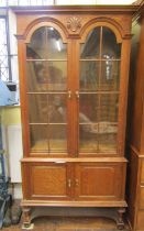 An Edwardian period oak two sectional bookcase partially enclosed by two fielded panelled doors