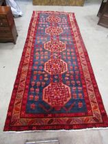 A corridor rug of Persian design with five interlocking hexagonal medallions on a blue ground