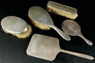 A mixed collection of silver backed hair and clothes brushes and two silver backed hand mirrors