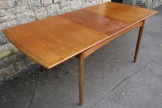 A vintage G plan teak dining table of rectangular form with moulded outline, single additional