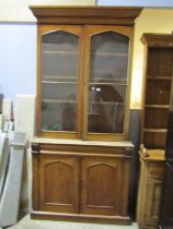 A Victorian mahogany library bookcase, the lower section enclosed by a pair of arched panelled doors