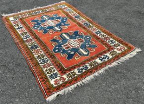 A Kazak Carpet with two large blue stepped lozenge on a pink ground, 210cm x 145cm