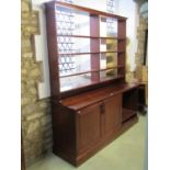 A bespoke mahogany bookcase cupboard the lower section enclosed by a pair of fielded panelled