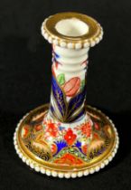 An early 19th century miniature Spode taper stick with beaded rims, richly decorated with Imari