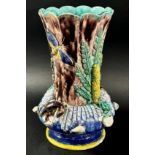 A late 19th century majolica vase, the fluted neck set within a circular ring encrusted with