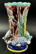 A late 19th century majolica vase, the fluted neck set within a circular ring encrusted with