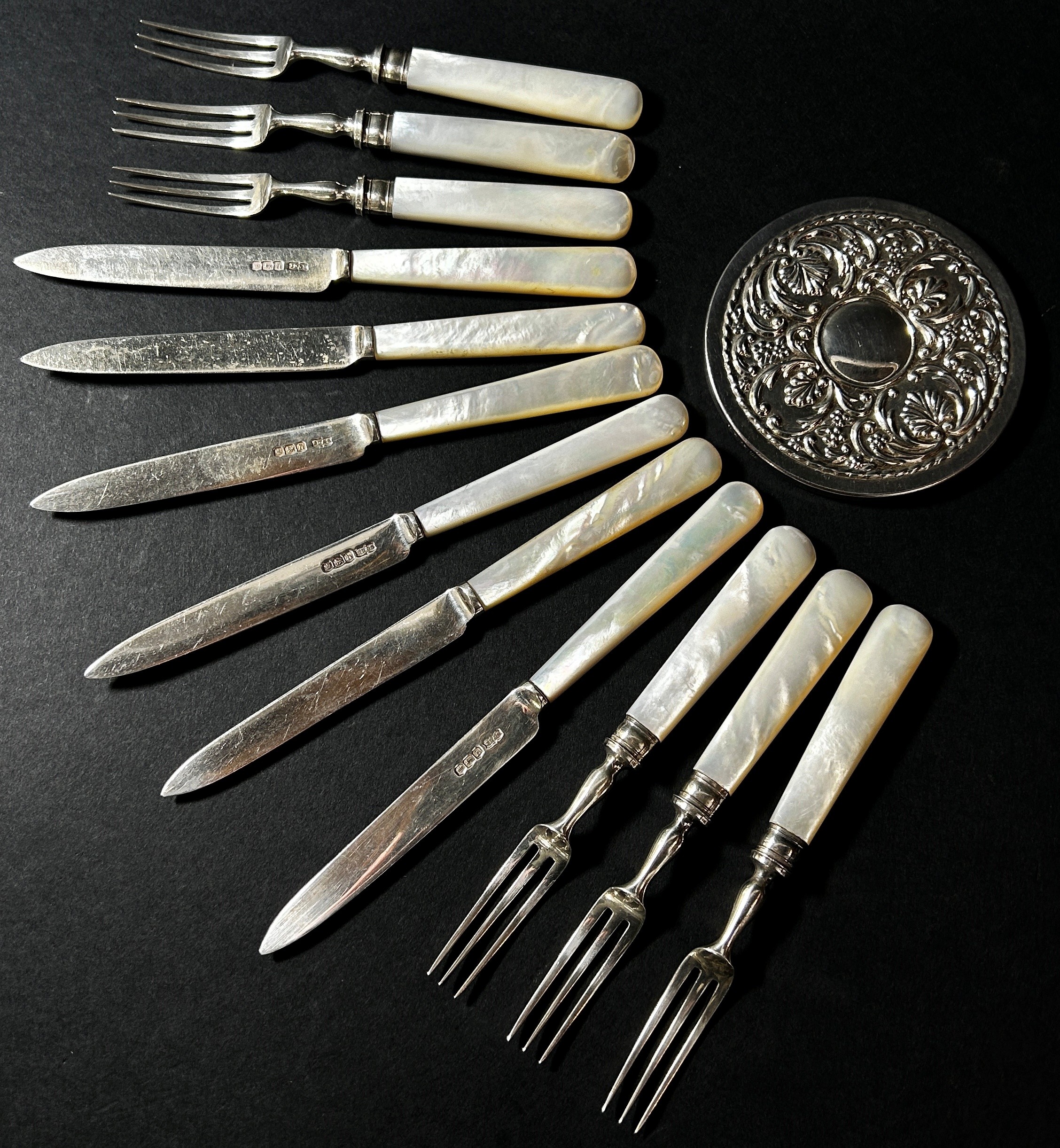 A Harrods mother of pearl set of silver fruit knives and forks and a small silver pocket mirror.