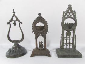 A 19th century cast iron watch stand with a person seated with a bird in an Indian archway, together