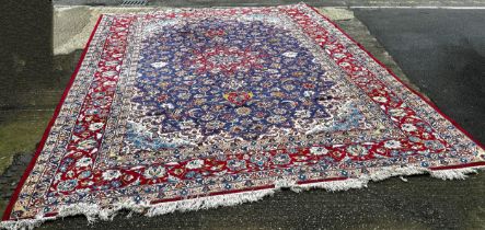 A large Isfahan carpet with a central star burst medallion with an all over floral pattern on a blue