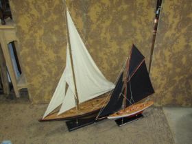 Two modal single mast yachts and stands