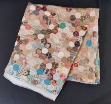 Large hand stitched traditional hexagon pattern patchwork quilt in printed cottons with older