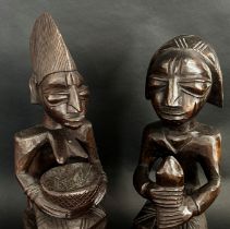 A pair of central African carved hardwood figures, possibly Yoruba, detailing a male, possibly an