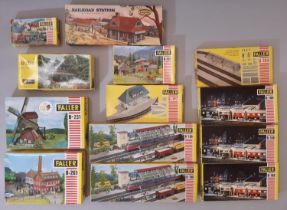 12 rail modelling kits of lineside buildings and accessories by Faller (11) and Aurora, all H0 gauge