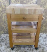 A modern Butcher’s block kitchen preparation table, with a thick block wood chopping board over a