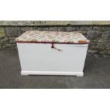 An old painted pine blanket box with later upholstered lid 48 cm high x 83 cm x 47 cm