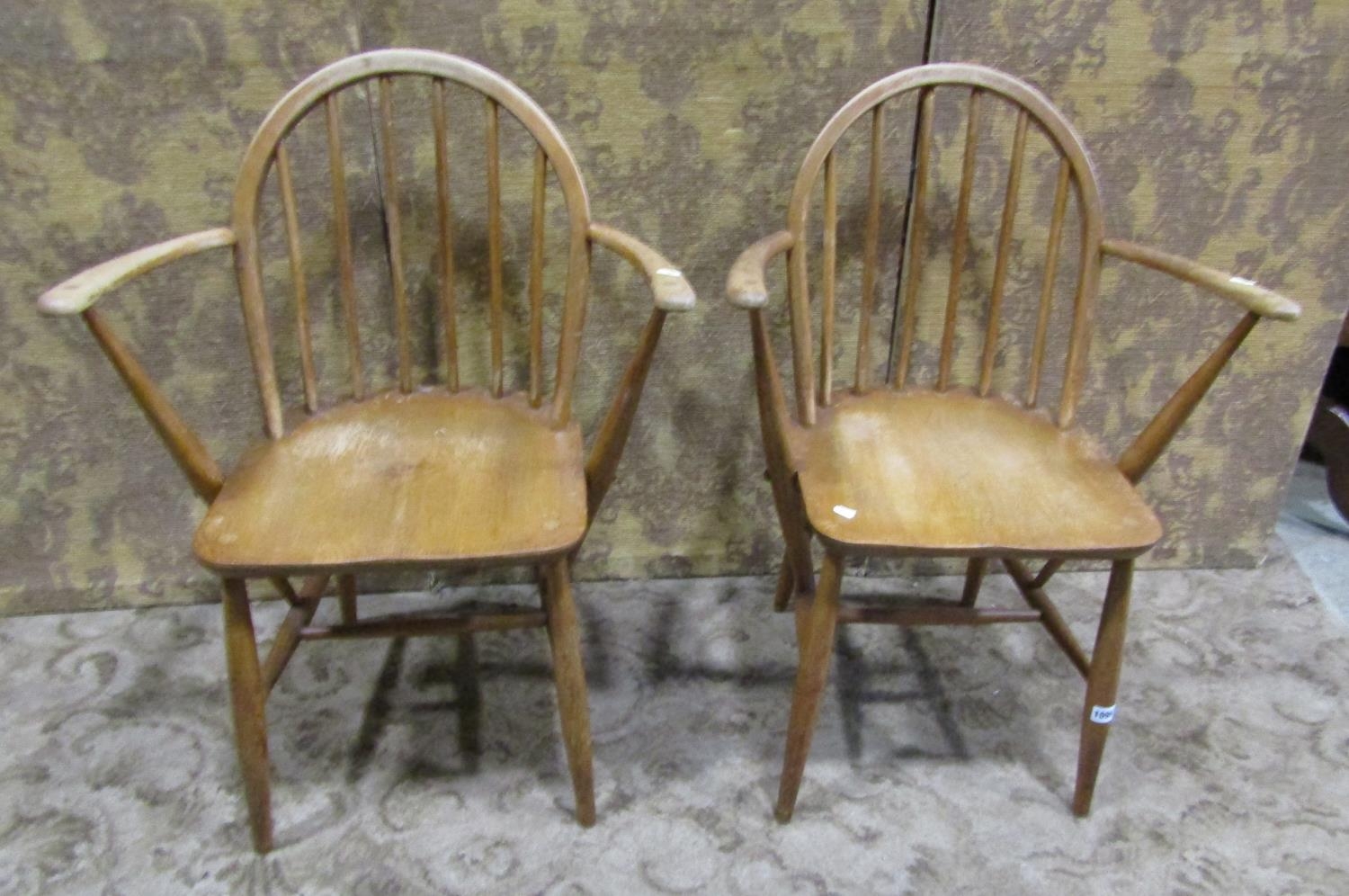 A Pair of vintage Ercol elm and beechwood stick back elbow chairs
