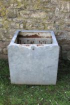 A reclaimed galvanised steel water tank of square cut and slightly rounded form (for use as a