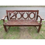A heavy gauge stained and weathered teak three seat garden bench to commemorate the millennium,