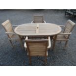 A contemporary weathered Cotswold collection garden table with oval slatted top raised on x framed