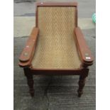 An early 20th century teak plantation chair, with curved woven rattan seat and folding / extending