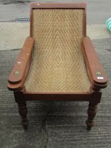 An early 20th century teak plantation chair, with curved woven rattan seat and folding / extending